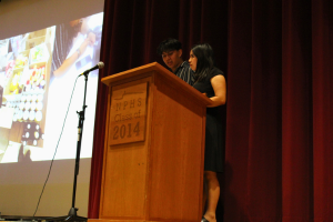 two students presenting from stage